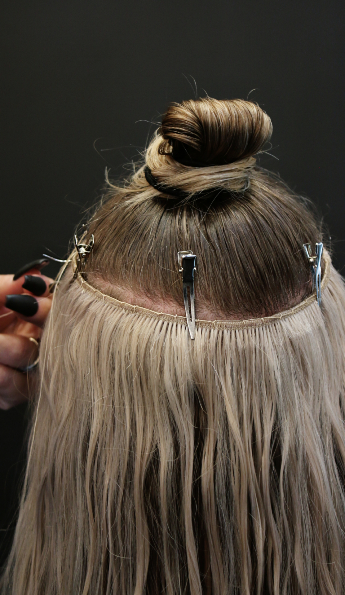 Blonde hair with sew-in weft extensions being installed, showing the beaded row and weft placement by Katie Cheatham in Louisville, KY