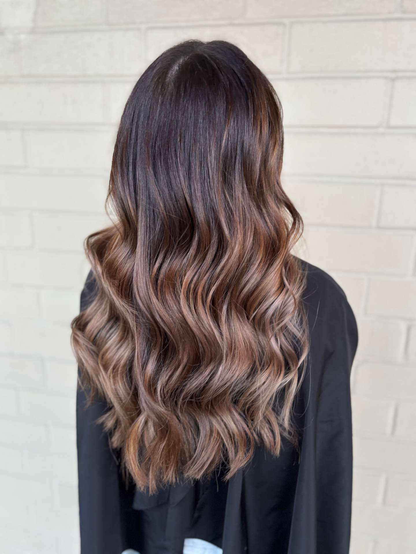 Dimensional brunette balayage hair color with warm copper and caramel tones done at a Louisville Kentucky salon